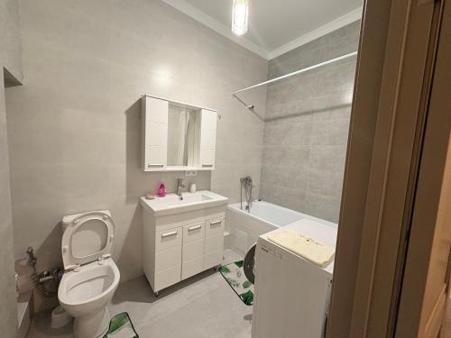 Apple city في Prigorodnyy: حمام مزود بمرحاض ومغسلة ومرآة