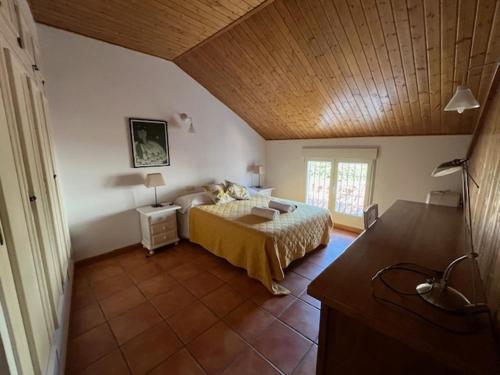 a bedroom with a bed and a wooden ceiling at Casa rural collao de lobo in Serradilla