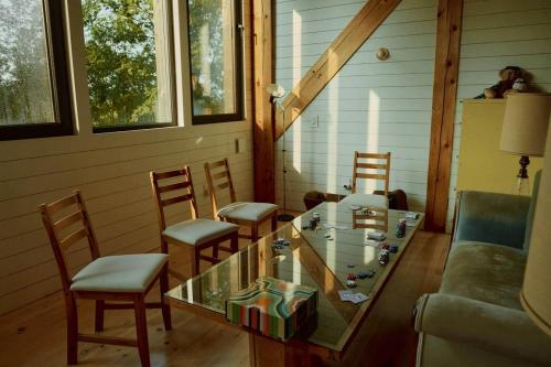 a living room with a glass table and chairs at Shatemuc, a magical getaway on the Hudson River in Kingston