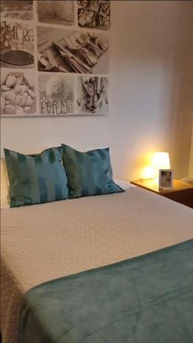 a bedroom with a bed with blue pillows and a lamp at House4U Vila Nova in Vila Nova de Gaia