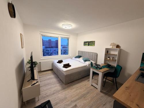 une chambre avec un lit, une table et une fenêtre dans l'établissement SkyView Studio Vlčince with private parking, à Žilina