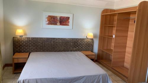 マナウスにあるFlat Vista Pôr do Solのベッドルーム(ベッド1台、本棚付)