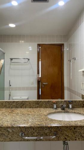 a bathroom counter with a sink and a mirror at Flat Vista Pôr do Sol in Manaus