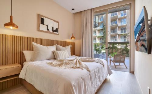 a bedroom with a bed and a large window at Bohari Las Arenas in Cabo San Lucas