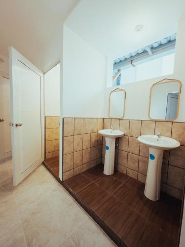 a bathroom with two sinks and two mirrors at Central Hostel Zona 4 in Guatemala