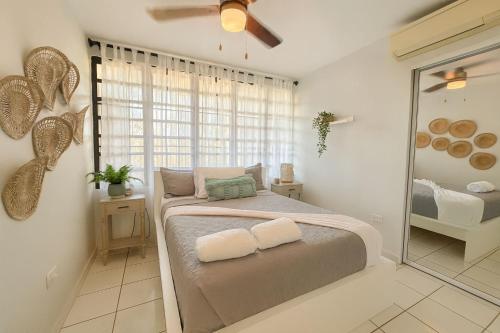 a bedroom with a bed and a large window at Tropical Tranquility - Corcega in Stella