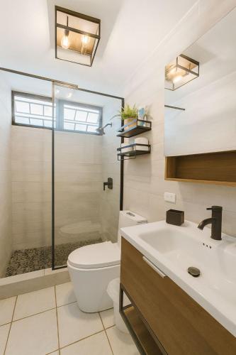 a bathroom with a toilet and a sink and a shower at Tropical Tranquility - Corcega in Stella