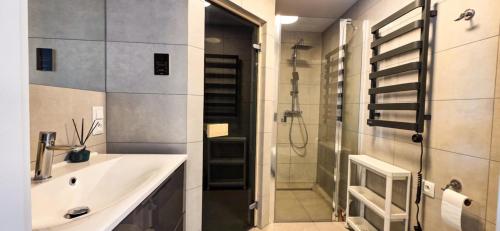 ein Badezimmer mit Waschbecken und Dusche in der Unterkunft Harnas in Säffle