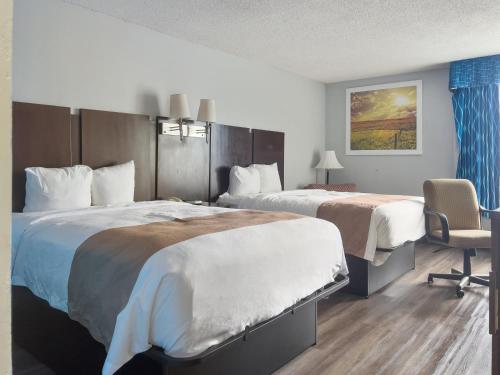 a hotel room with two beds and a chair at Havelock Hotel in Havelock