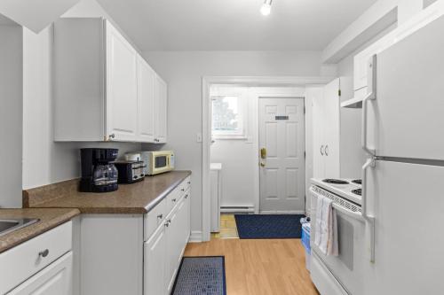 a kitchen with white cabinets and a white refrigerator at Relaxing 2BR Parking Self Check-In in Torbay