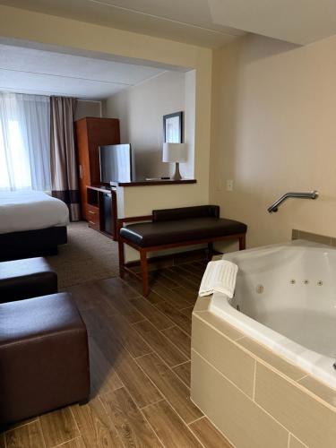 ウィルクス・バリにあるComfort Inn & Suites Wilkes Barre - Arenaのバスタブとベッド付きのホテルルームです。