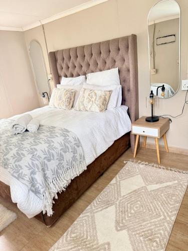 a bedroom with a large bed and a mirror at Royaltics place in Weltevredenpark