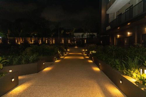 een loopbrug met verlichting voor een gebouw 's nachts bij Urban Nook, The Bantree in Accra