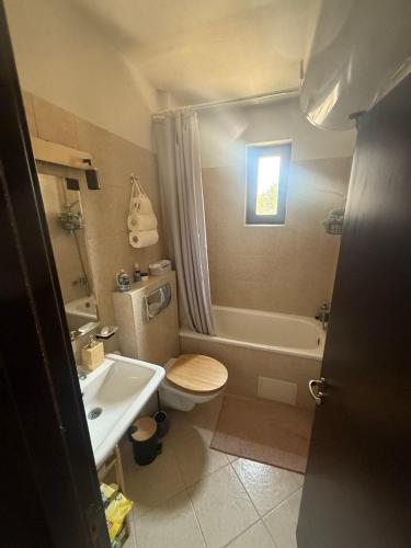 a bathroom with a toilet and a tub and a sink at Tranquility Apartment Pirin Golf in Razlog