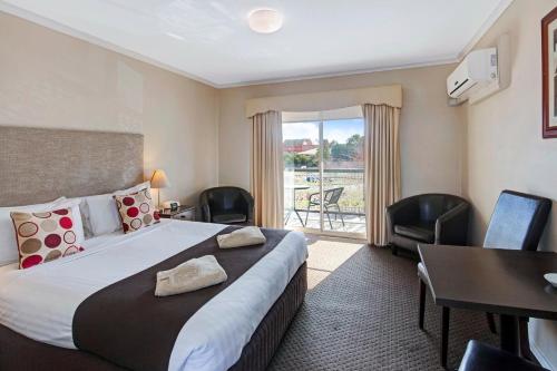 a hotel room with a large bed and a balcony at Ballarat Central City Motor Inn in Ballarat