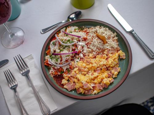 Un plato de comida en una mesa con una ensalada. en Nk Hotel Nekié Tepic, en Tepic