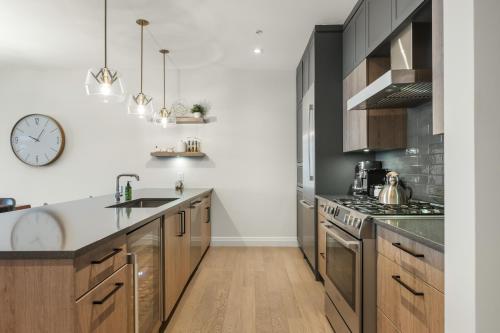 蒙特朗布朗Tremblant Prestige - Horizon 2-204的厨房配有木制橱柜和墙上的时钟