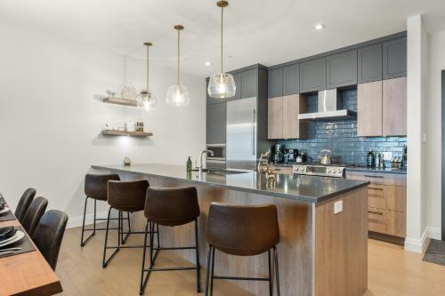 a kitchen with a large island with bar stools at Tremblant Prestige - Horizon 2-204 in Mont-Tremblant