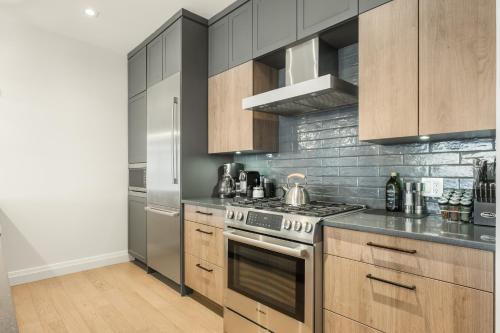 a kitchen with stainless steel appliances and wooden cabinets at Tremblant Prestige - Horizon 2-204 in Mont-Tremblant