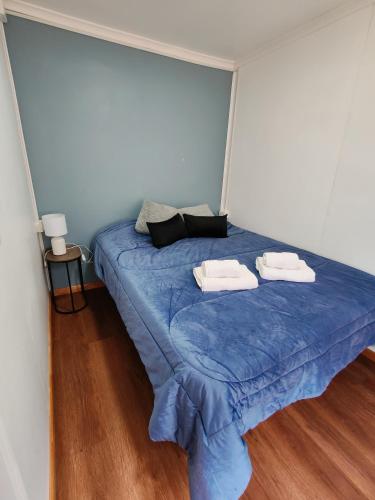 uma cama azul com duas toalhas em cima em Ruka Austral em Punta Arenas