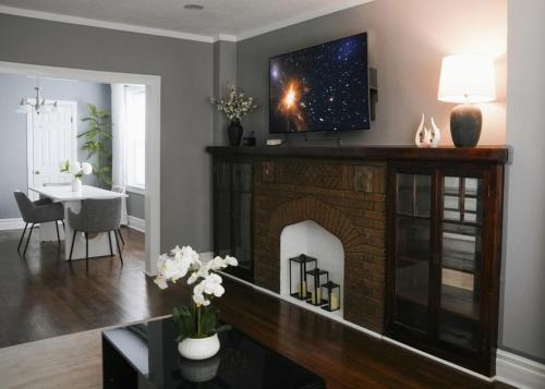 a living room with a fireplace with a tv above it at 2BR w/ Workspace - Coffee Bar - Near Transit in Chicago