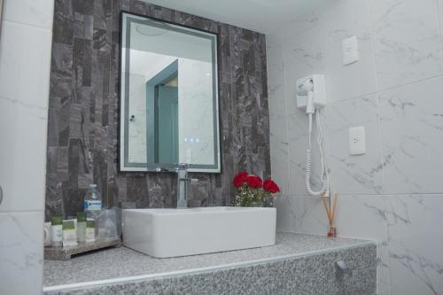 a bathroom with a white sink and a mirror at Nk Hotel Nekié Tepic in Tepic