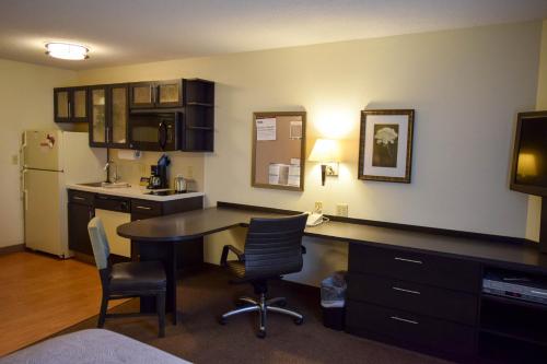 a kitchen with a table and chairs and a refrigerator at Candlewood Suites Wichita - Airport by IHG in Wichita