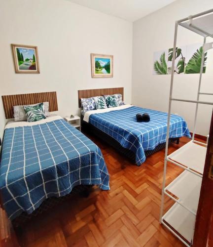 a bedroom with two beds and a ladder at Apartamento completo no centro in Teresópolis