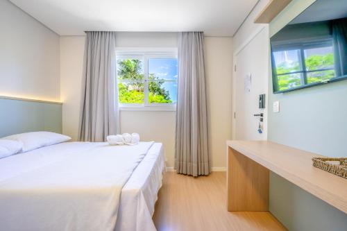 Pousada Encanto da Vila في بلوميناو: غرفة نوم بها سرير ونافذة