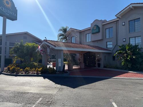 a hotel building with a flag in a parking lot at La Quinta by Wyndham St Petersburg-Clearwater in Pinellas Park