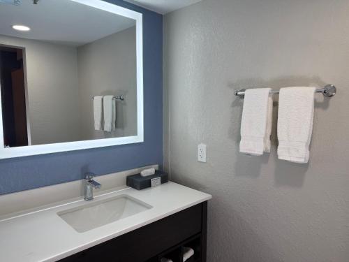 a bathroom with a sink and a mirror and towels at La Quinta by Wyndham Pinellas Park St Peterburg Clearwater in Pinellas Park