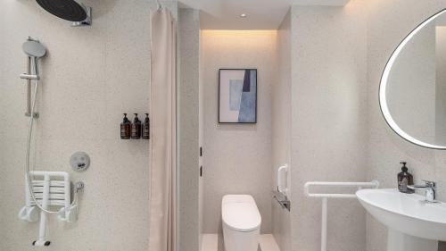 a bathroom with a shower and a toilet and a sink at EVEN Hotel Chengdu Phoenix Mountain by IHG in Chengdu