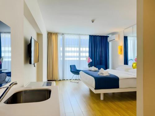 PANORAMA sea VIEW suite APARTMENTS في باتومي: غرفة فندق مع سرير ومغسلة