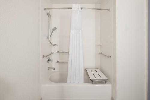 a white bathroom with a shower with a sink at Garner Hotel Mahwah by IHG in Mahwah