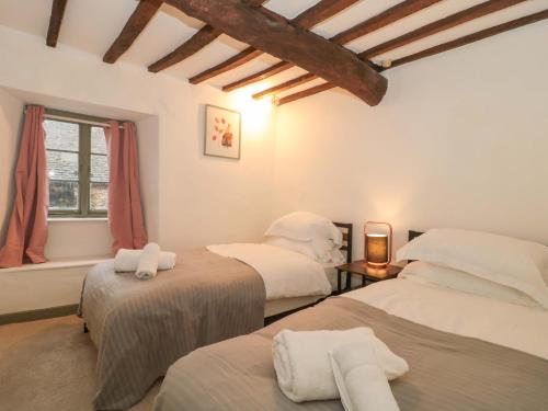 Un dormitorio con dos camas y una ventana. en 6 Priory Lane, en Burford