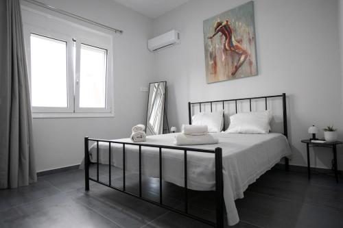 a bedroom with a bed and a painting on the wall at Perivola apartment in Patra