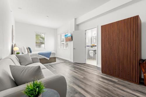 a living room with a couch and a wooden door at Bluebird Suites at The Apex Miami in Miami Beach