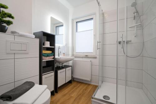 a white bathroom with a shower and a sink at Ferienwohnung-Finn-EG in Rechlin