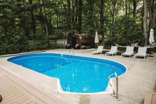 Loma House في Sawyer: مسبح ازرق مع كراسي وطاولة