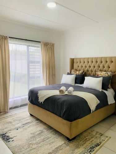 a bedroom with a large bed with two teddy bears on it at 2 Bed 2 Bath Private Garden Apartment in Fourways