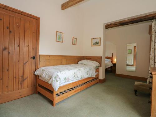 een slaapkamer met een bed en een houten deur bij Ticklepenny in Cornisholme