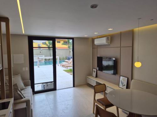 a living room with a table and a dining room at Solena in Camburi