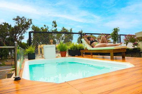 a woman laying on a chair next to a swimming pool at Gya Hoteles in Arequipa