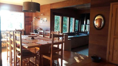 Un comedor con una mesa y una cocina. en Preciosa casa rural, Llau llao,Castro, Chiloé, en Castro