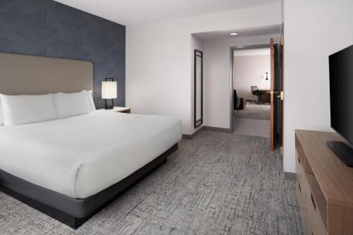 Embassy Suites by Hilton Franklin Cool Spring في فرانكلين: غرفة نوم بها سرير أبيض كبير وحمام