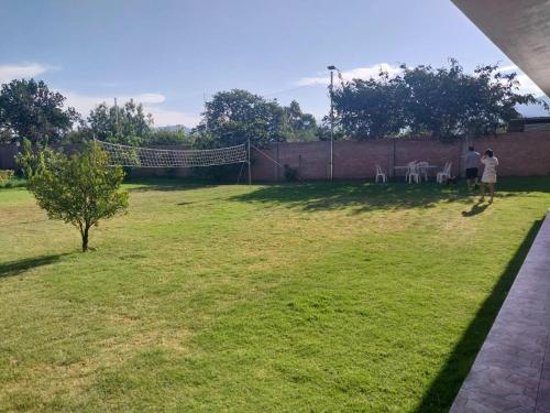 duas pessoas em pé num gramado com uma cerca em La Retama Houstime em Ayacucho