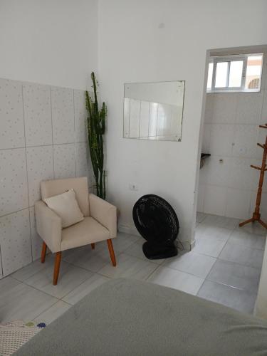 a living room with a chair and a mirror at Hospedagem da Lu in Paraty