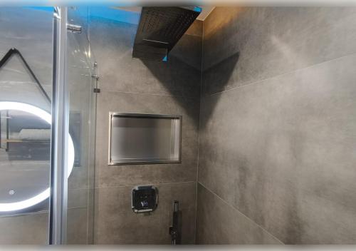 a bathroom with a shower and a mirror at 21 Gramm Das Verborgene mit Tiefgarage in Sasbachwalden