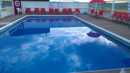 a pool with a reflection of the sky in the water at Oasis Motel in Antigonish