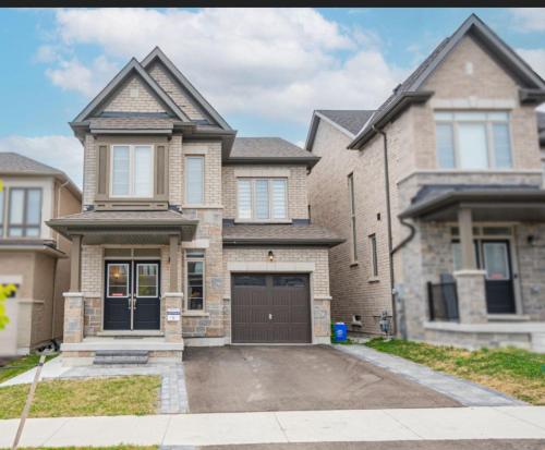 a large brick house with a garage at Oshawa Two Bedroom Private Suite in Oshawa
